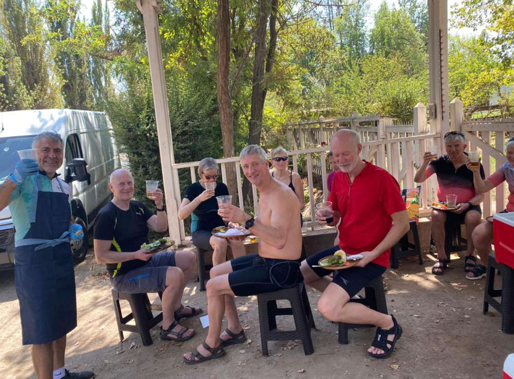 Grupo compartiendo un picnic a la sombra de los árboles